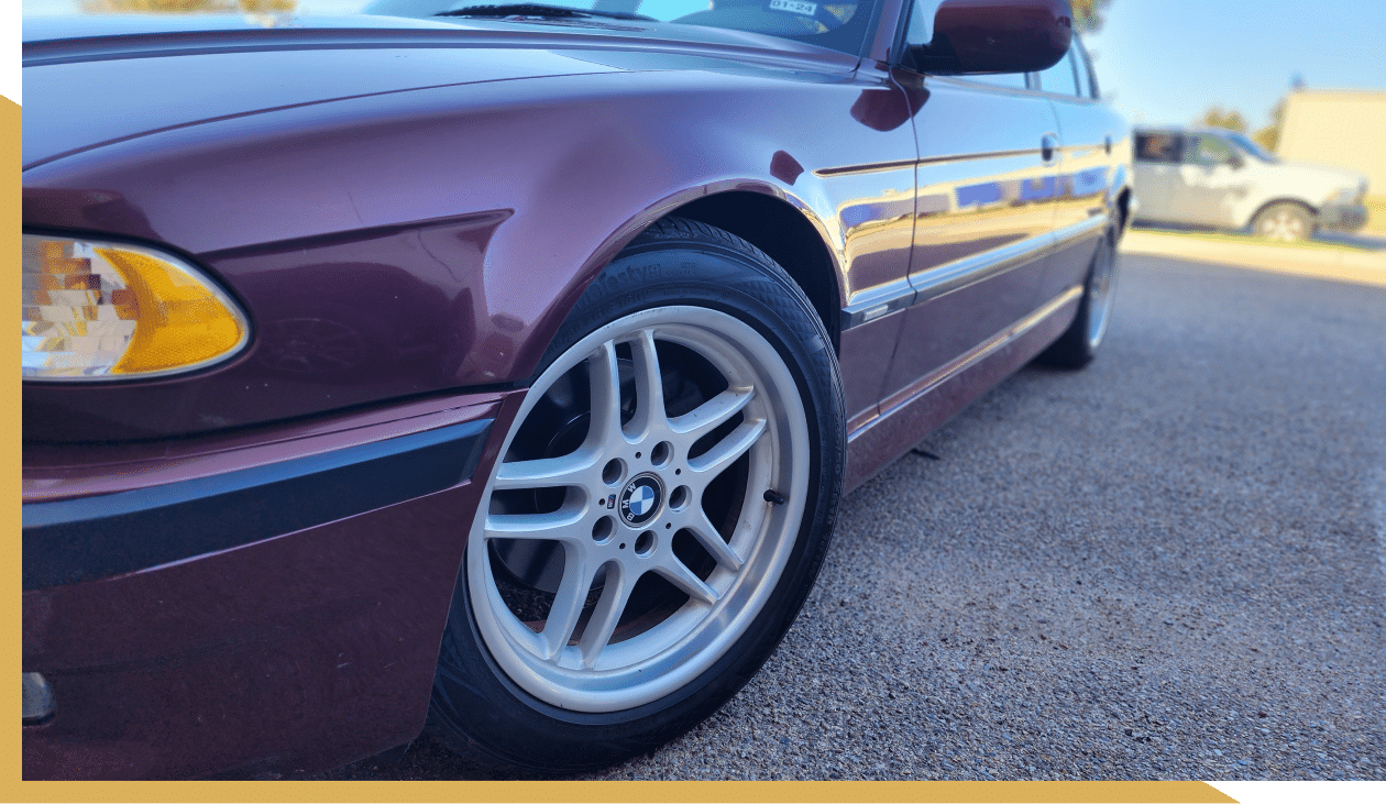 BMW repair in Amarillo, TX at Panhandle Eurotech Automotive. An image Side view of a BMW with a focus on the front wheel and alloy rim.